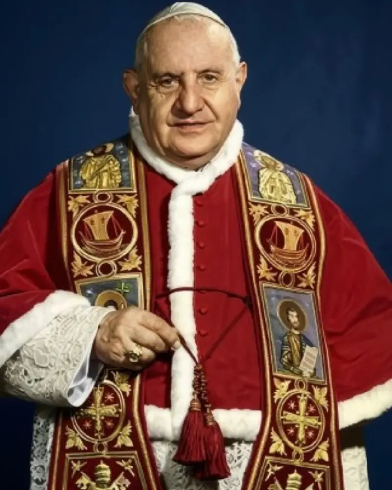 Uśmiechnięty papież święty Jan XXIII w białej sutannie i czerwonej pelerynie mozzetta.