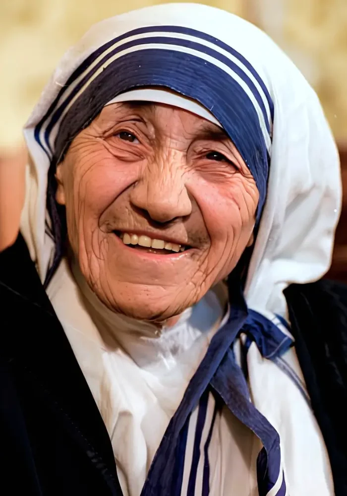 Święta Matka Teresa z Kalkuty w tradycyjnym biało-niebieskim sari, uśmiechnięta.